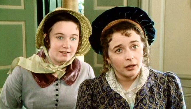 Kitty Bennet (Polly Maberly) and Lydia Bennet (Julia Sawalha) in the 1995 Pride & Prejudice Movie still photograph from the 1995 production of Pride & Prejudice, showing Kitty Bennet (Polly Maberly) and Lydia Bennet (Julia Sawalha) looking off-screen with expectant facial expressions.